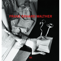 Schwarz-Weiß-Foto einer Person, die mit dem Kopf in einem Stoffobjekt zwischen Textilien liegt. Darüber steht in roter Schrift der Name FRANZ ERHARD WALTHER.