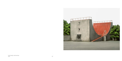 Eine surreale Architektur aus Beton, bei der ein Gebäude mit einer roten Halfpipe kombiniert ist, die die Markierungen eines Tennisplatzes aufweist. Daneben steht ein Schiedsrichterstuhl auf einem Sockel.