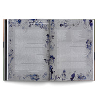 Ein aufgeschlagenes Buch, das eine Doppelseite mit deutschem Text und skizzenhaften, surrealen Illustrationen in Blau und Schwarz zeigt. Die Zeichnungen von menschlichen Figuren in einem Bistro sind um die Textspalten herum angeordnet.